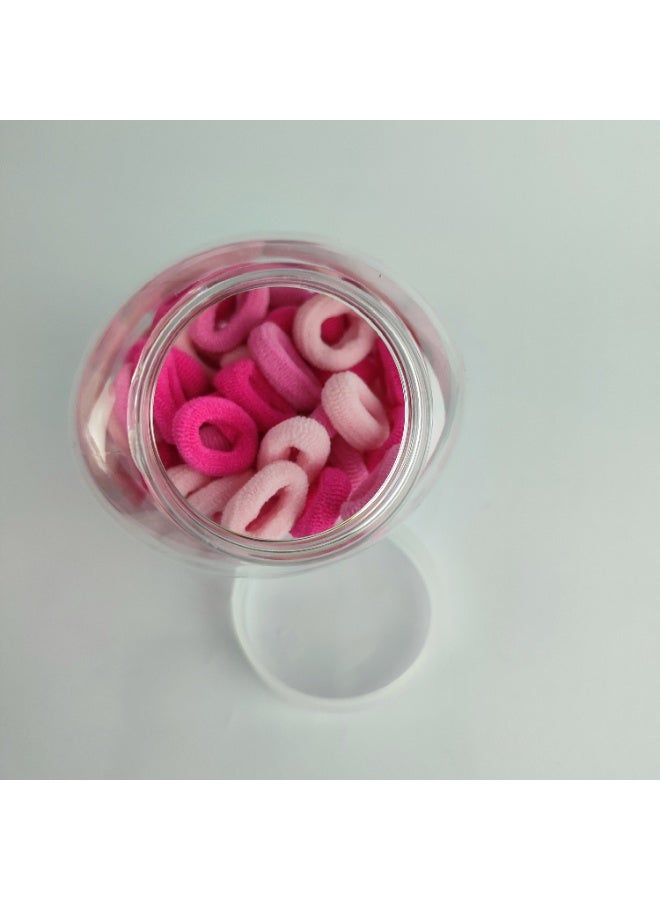 A plastic jar containing small elastic hair clips - Image 5