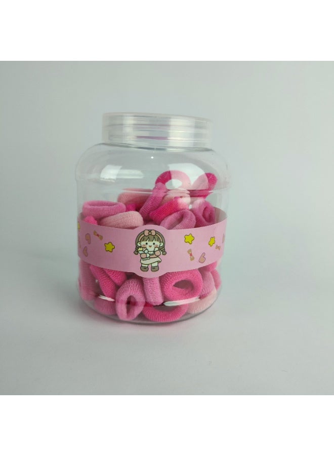 A plastic jar containing small elastic hair clips - Image 1