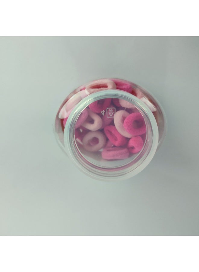 A plastic jar containing small elastic hair clips - Image 4
