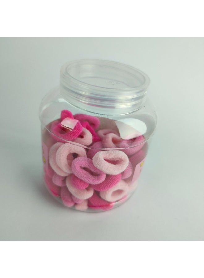 A plastic jar containing small elastic hair clips - Image 3