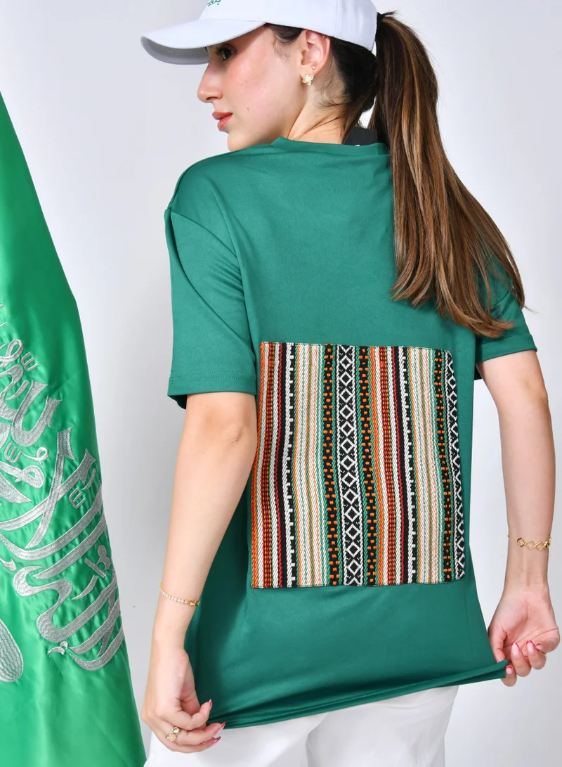 عبايات حوراء تيشيرت أخضر بتطريز شعار عزنا بطموحنا مع سدو من الخلف