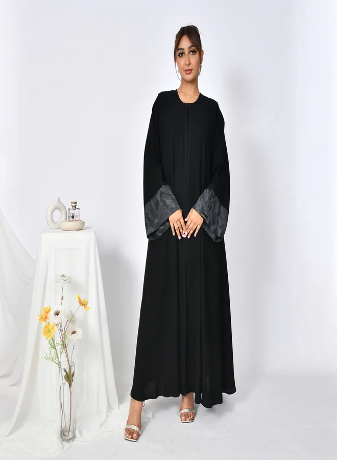 HAWRAA ABAYA Elegant abaya with a closed cloche cut and a silk jacquard insert on the sleeves.