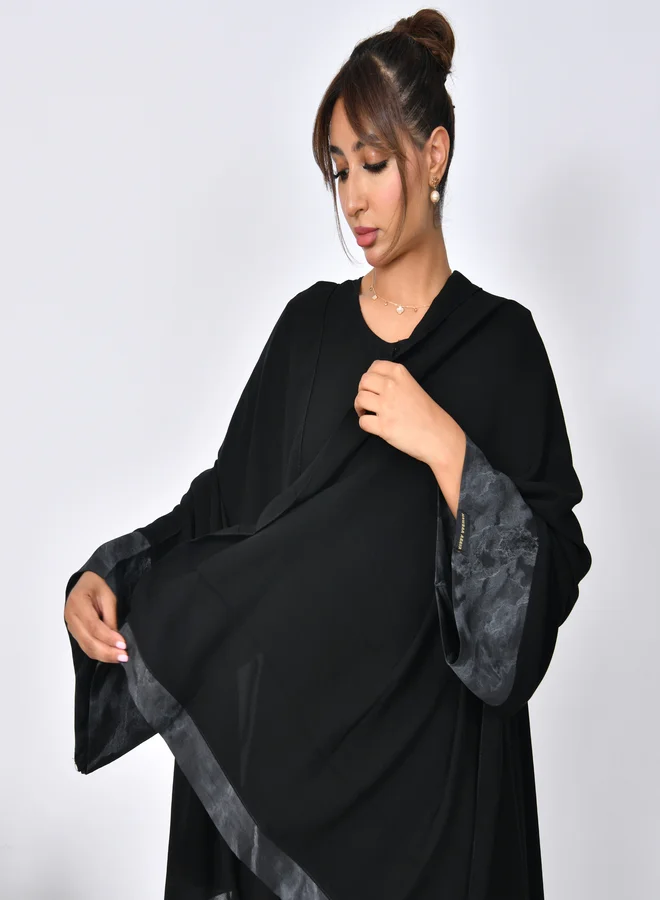 HAWRAA ABAYA Elegant abaya with a closed cloche cut and a silk jacquard insert on the sleeves.