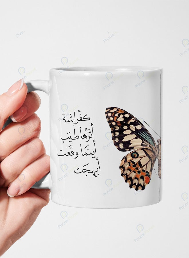كوب من السيراميك مطبوع عليه عبارة كفراشة أثرها طيب أينما وقعت أبهجت ويتميز بمقبض مريح