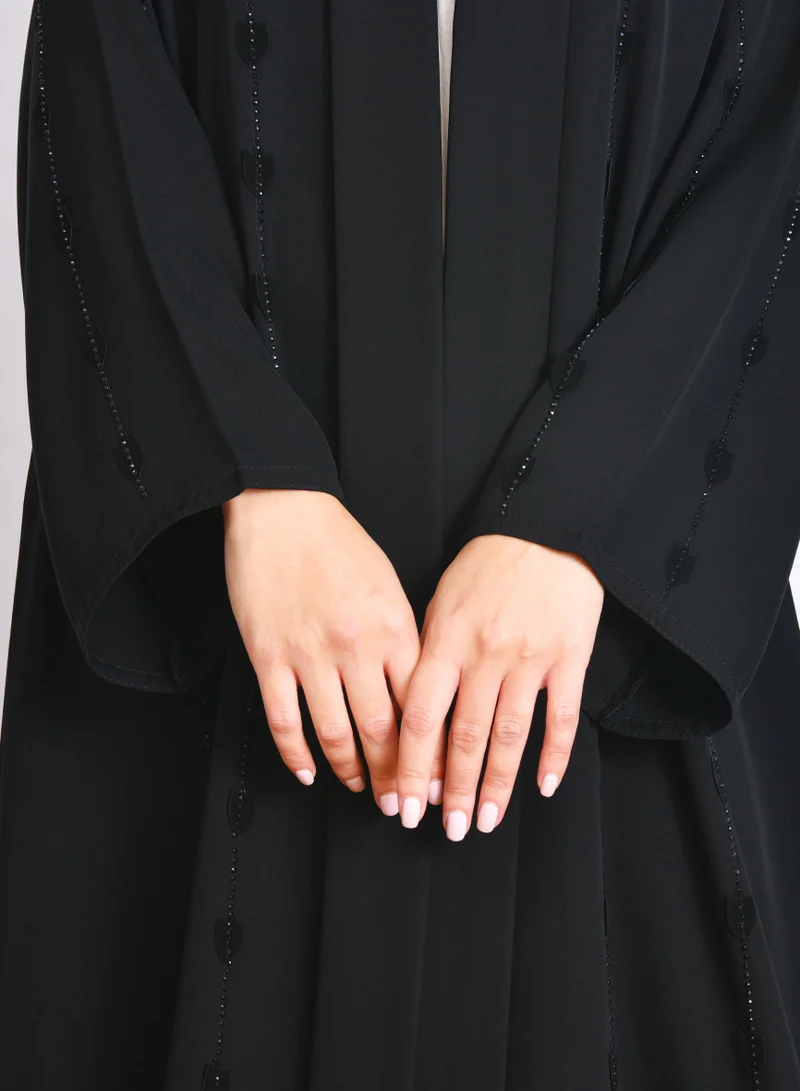 HAWRAA ABAYA Elegant black abaya with a fluid silhouette, decorated with embroidery and stones