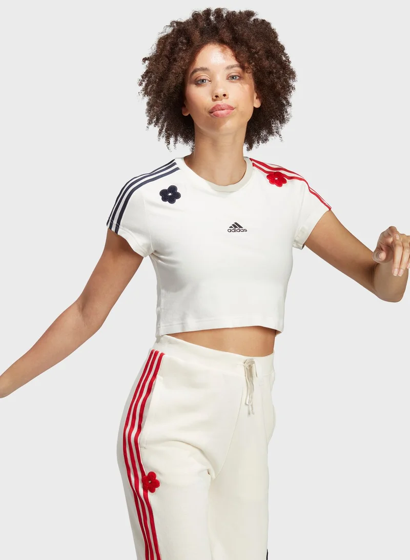 adidas تيشيرت قصير بخطوط الماركة وطبعة زهرة