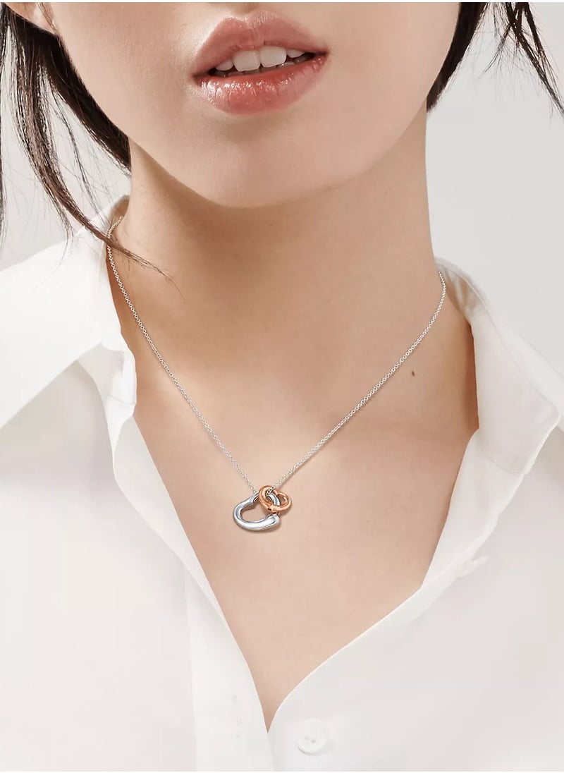 Elsa Peretti® Open Heart pendant in sterling silver and 18k rose gold.