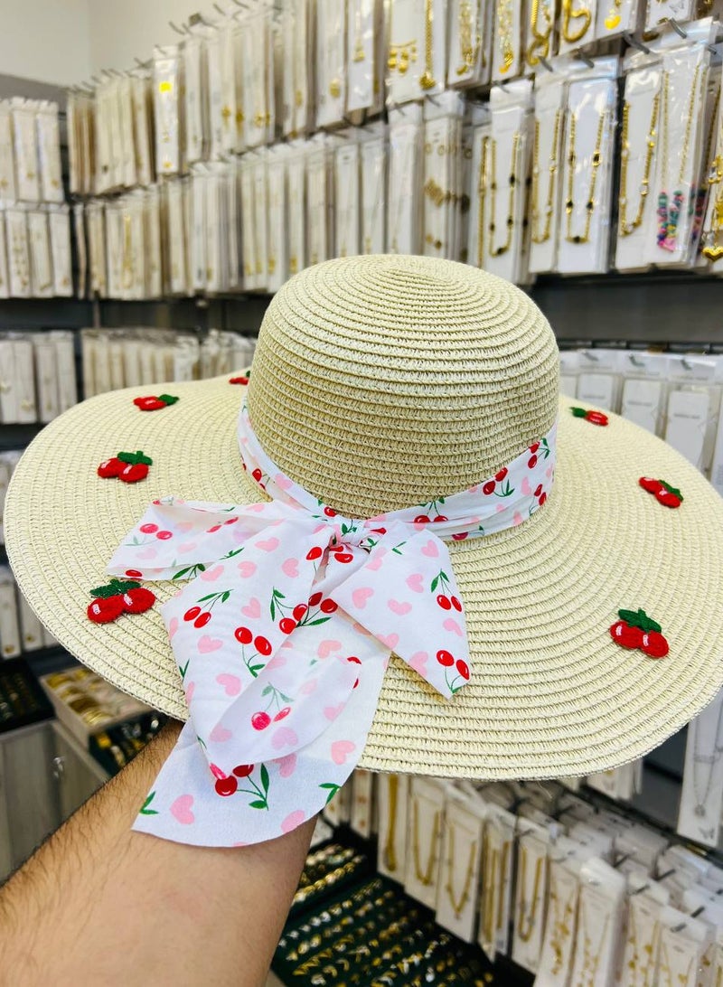 A distinctive girls' straw hat with cute cherry embroidery and a fabric bow featuring a cherry and heart motif. A fun and soft style that adds a lively touch to any summer look. Perfect for the beach, outings, and photoshoots. Lightweight, comfortable, and elegantly protects from the sun.