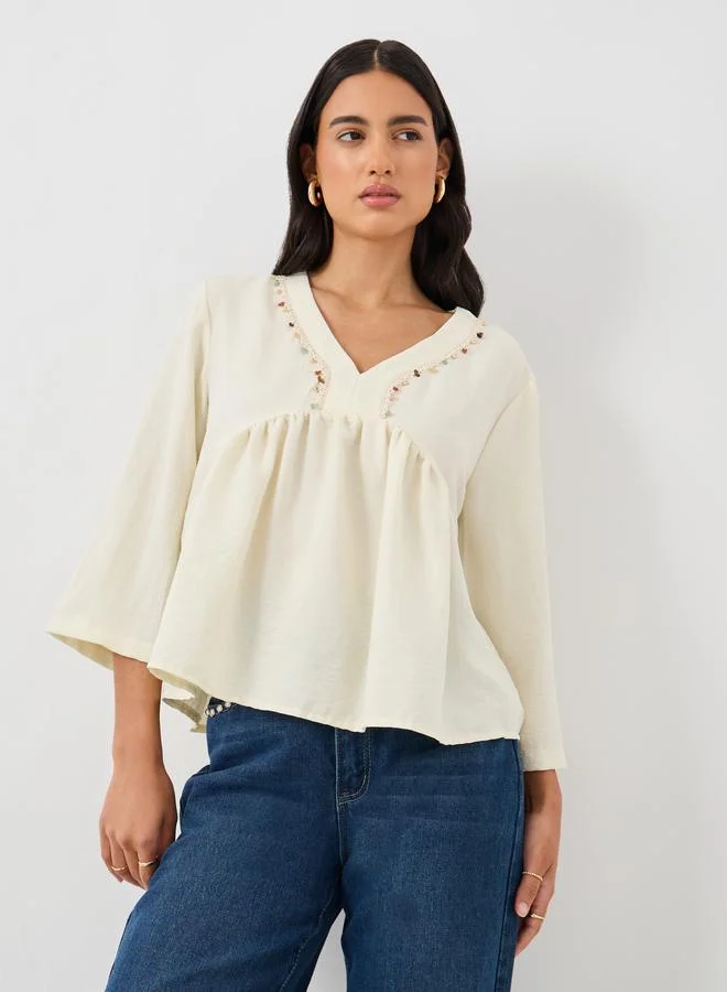 ستايلي بلوزة بيبلوم بياقة على شكل حرف  وتفاصيل دانتيل مزينة