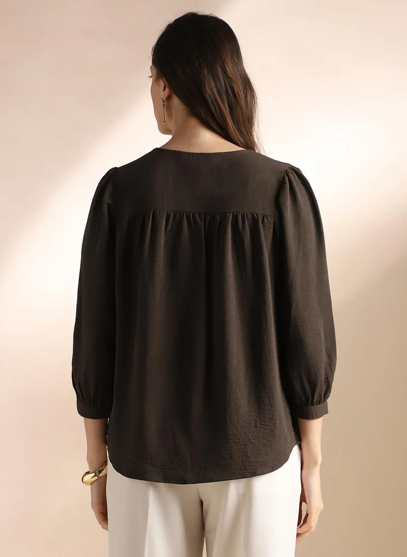 جلو باص بلوزة نسائية بنية بتصميم ذاتي وياقة على شكل حرف  وتفاصيل مجمعة للعمل