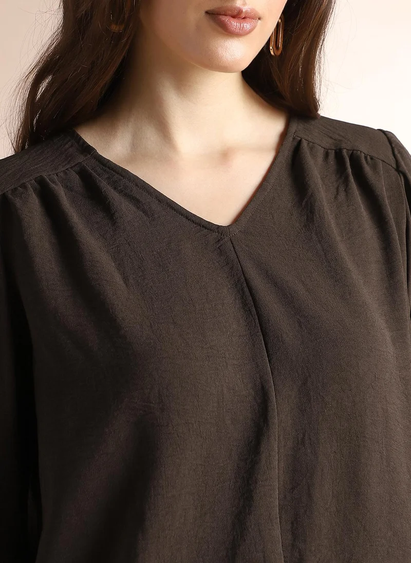 جلو باص بلوزة نسائية بنية بتصميم ذاتي وياقة على شكل حرف  وتفاصيل مجمعة للعمل