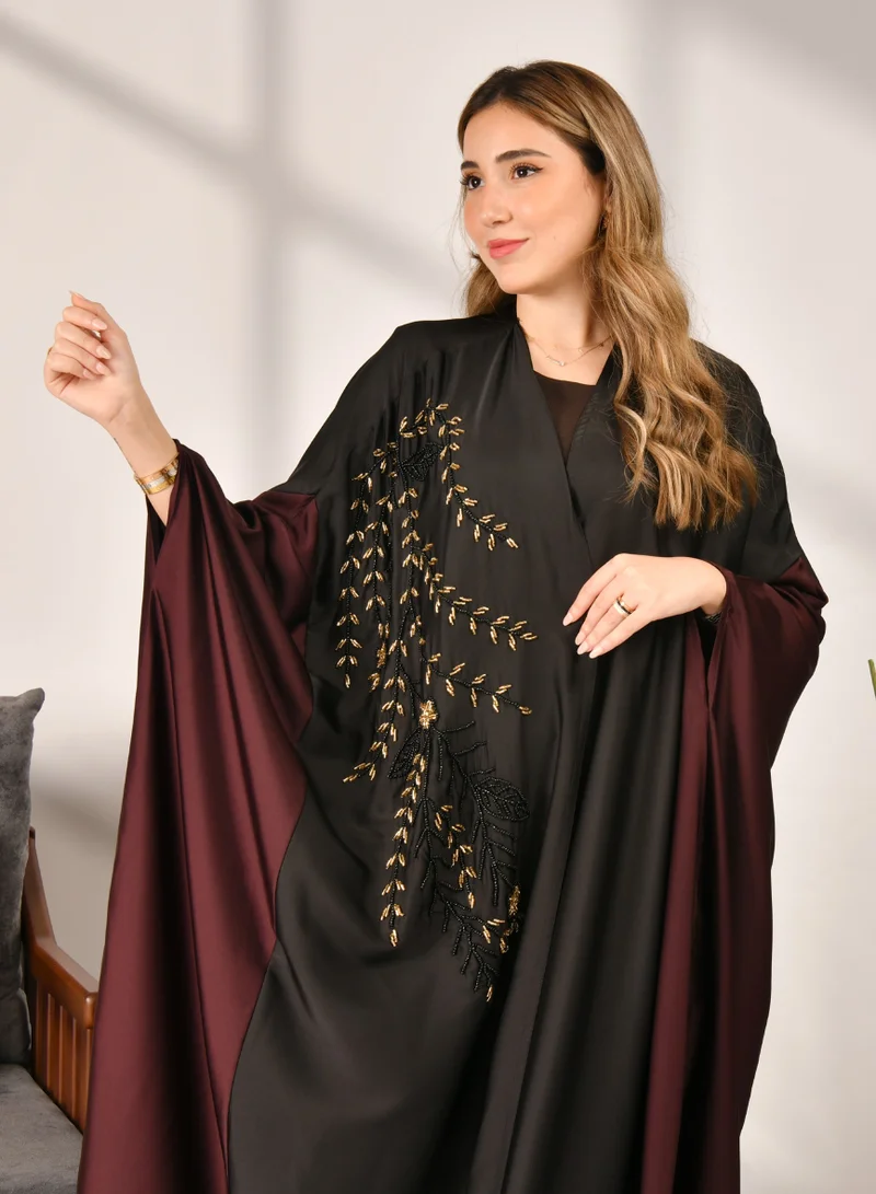 HAWRAA ABAYA Bisht-style wrap abaya made of black and burgundy silk decorated with a luxurious sash on the side and includes a set veil