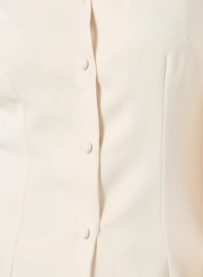 ستايلي بلوزة سادة بتفاصيل أزرار وأكمام طويلة