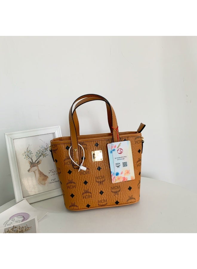 MCM حقيبة توت ميني مونوغرام بني من MCM مع مقبض علوي وإغلاق بسحاب