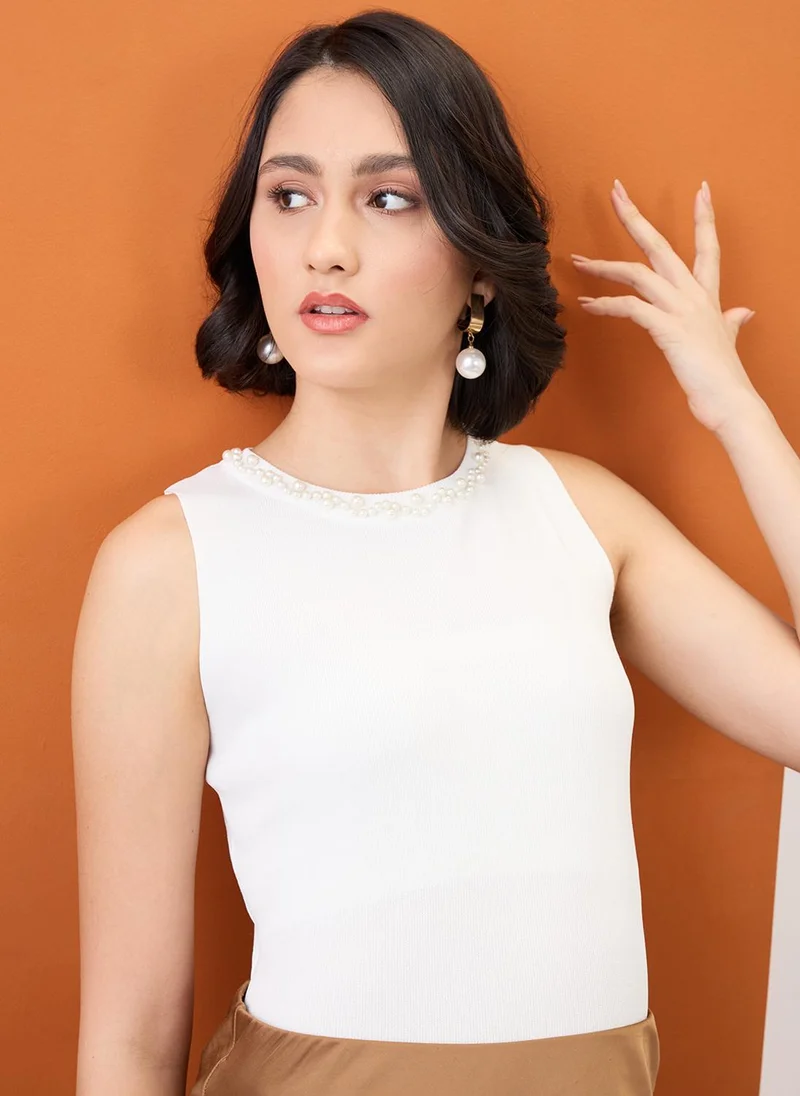 جلو باص بلوزة نسائية بيضاء بياقة مزينة باللؤلؤ ومضلعة