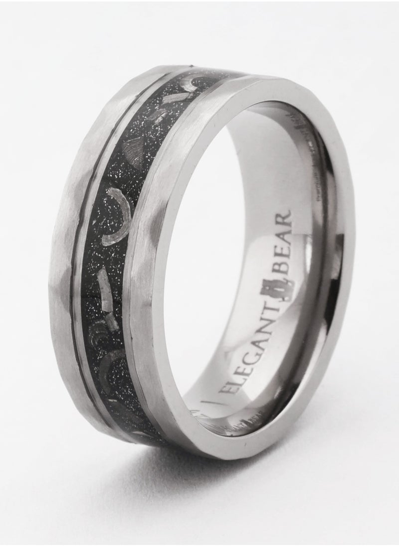 A ring made of titanium in silver color, inlaid with artificial meteorites and silver leaves.