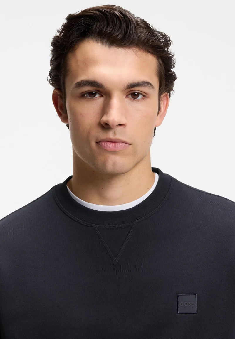 بوس سويت شيرت قطن تيري بقصة مريحة مع رقعة شعار