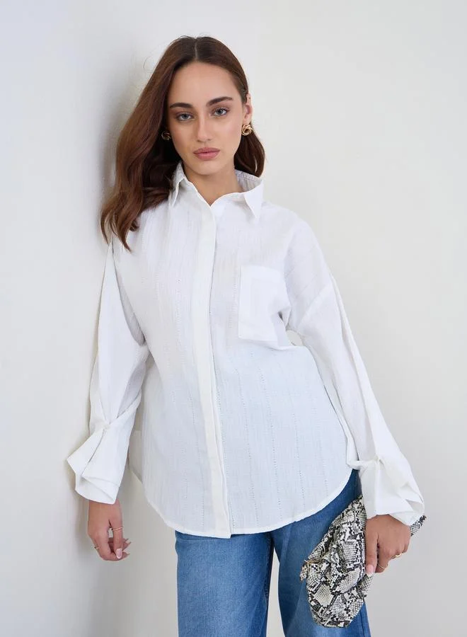 ستايلي بلوزة واسعة بتفاصيل بارزة الملمس مع أكمام بأساور