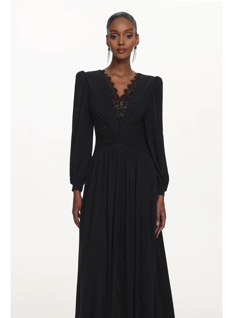 بيلا بارنيت فستان ماكسي أسود أنيق من لياكو، بياقة على شكل حرف V وأكمام طويلة، مزين بالدانتيل.