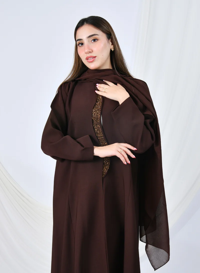 HAWRAA ABAYA An elegant abaya that combines simplicity and luxury with a quarter-length hem embellished with shawl detailing at the front edges | Brown with gold shawl detailing