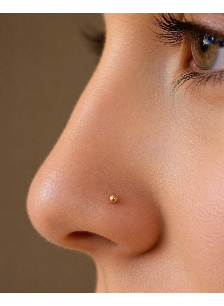 Luxuria These gold nose rings for women feature a simple and elegant design. Their small, delicate size creates a subtle yet understated look, while a small gold ball adds a touch of feminine charm. The design is suitable for everyday wear and easily complements various outfits. - Image 1