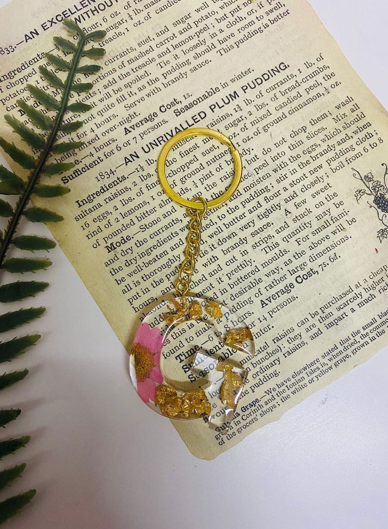 Keychain decorated with dried roses and gold leaf letter G made of luxurious resin
