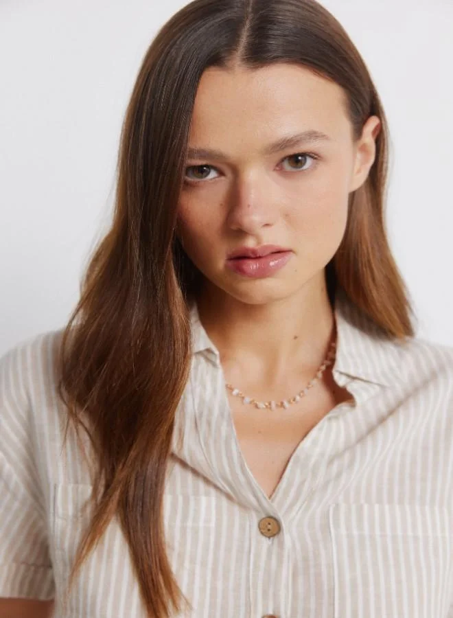 Springfield Linen shirt. Short folded sleeve. V-neck shirt collar. Front buttons. Patch pockets.