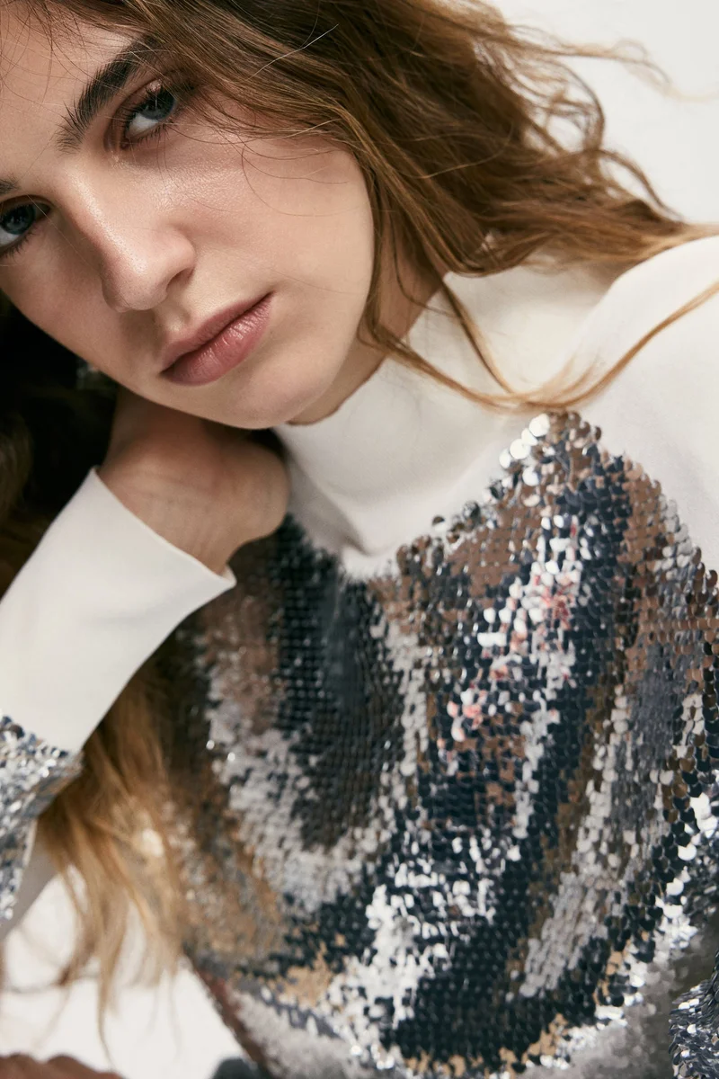 اتش اند ام بلوزة مزخرفة بالترتر ومزوّدة ببطانة على الكتف