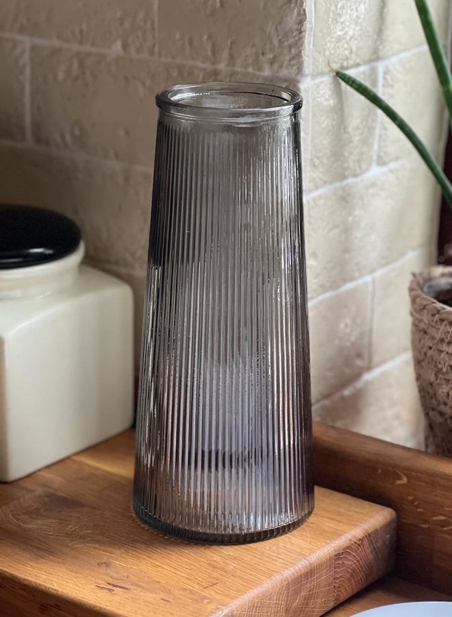 سويس كانتون مزهرية زجاجية فاخرة بلون أسود شفاف بتصميم مخطط عمودي أنيق – ارتفاع 20 سم وقطر 10 سم، مثالية لتنسيقات الزهور أو كقطعة ديكور منفردة، تعكس الضوء بأسلوب راقٍ، مناسبة للمنزل والمكتب