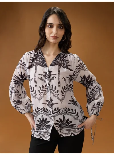 جلو باص بلوزة نسائية بنقوش قبلية باللونين الأسود والأبيض وأكمام أسقفية بياقة على شكل حرف