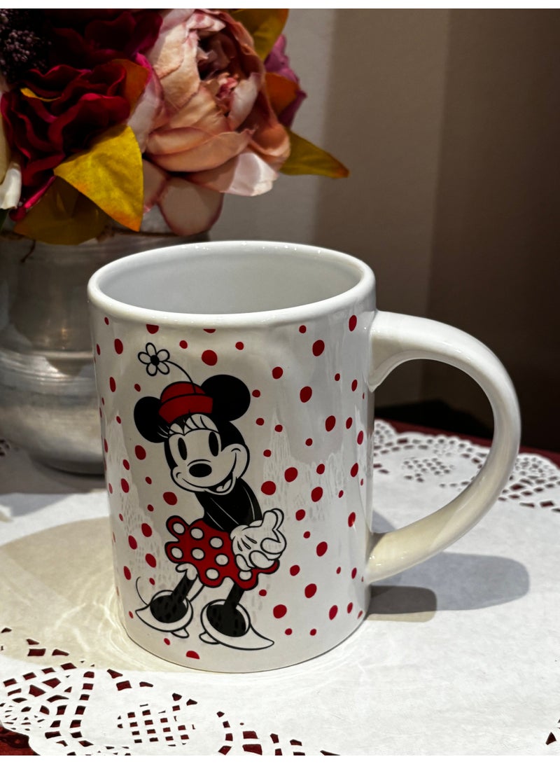 Minnie Mouse This is a charming ceramic mug in white, decorated with small red polka dots. The front side features the beloved cartoon character Minnie Mouse in a playful design, while the back side is adorned with a bright red heart, adding a touch of love and warmth to the mug. - Image 2