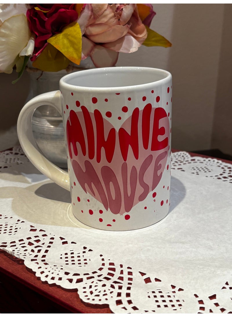 Minnie Mouse This is a charming ceramic mug in white, decorated with small red polka dots. The front side features the beloved cartoon character Minnie Mouse in a playful design, while the back side is adorned with a bright red heart, adding a touch of love and warmth to the mug. - Image 3