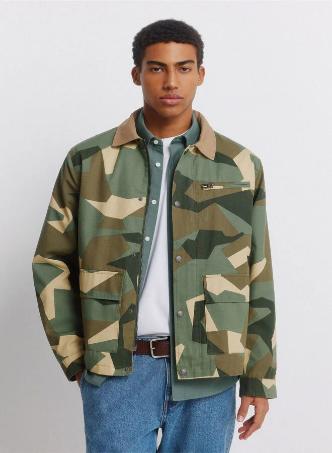 Springfield Camouflage print cotton and polyester blend ripstop texture lightweight short parka with contrast cotton shirt collar, zip fastening and snap buttons, patch pockets with snap button, zip pocket on chest, inner pocket, adjustable cuffs, and decorative label detail.