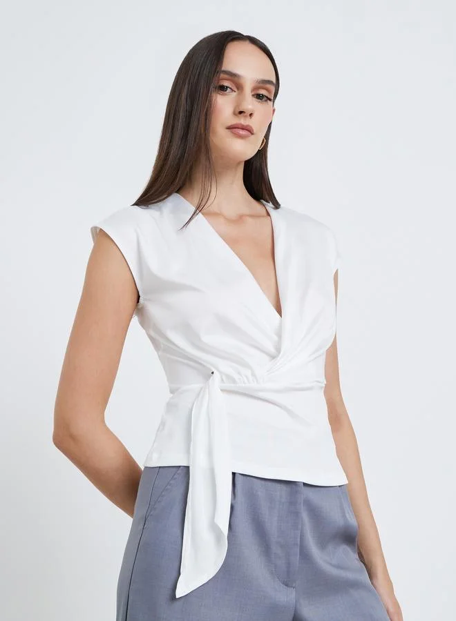 ستايلي بلوزة ملفوفة بعقدة أمامية باللون الأبيض