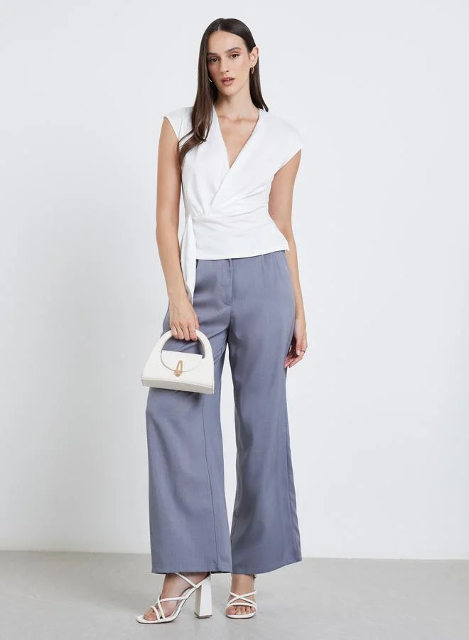 ستايلي بلوزة ملفوفة بعقدة أمامية باللون الأبيض