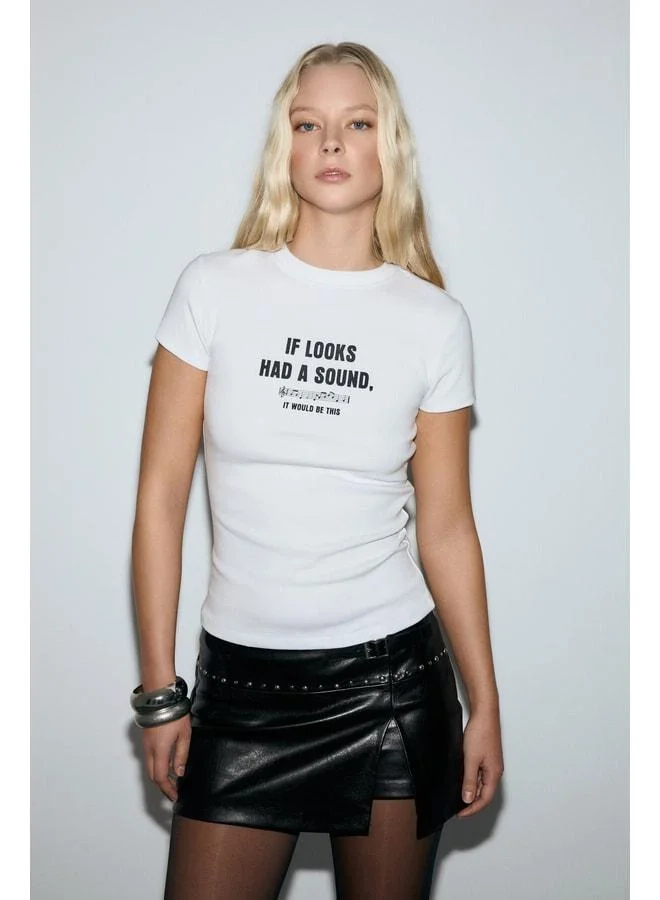 إتيكيت قميص T‑Shirt أبيض بفتحة عنق دراجة بتفاصيل مطبوعة وقماش ناعم ومرن من كاسيلينا للنساء.