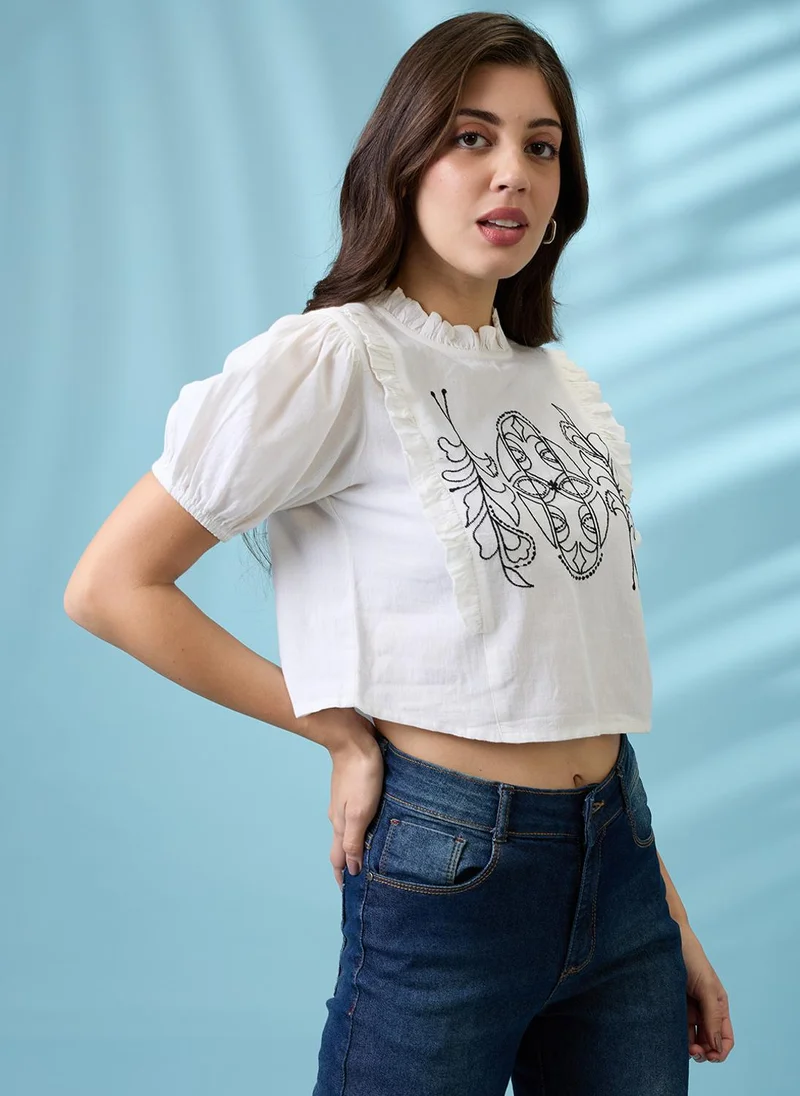 جلو باص بلوزة كروب نسائية بيضاء بياقة عالية وأكمام منفوشة وتفاصيل مطرزة من جلوبس