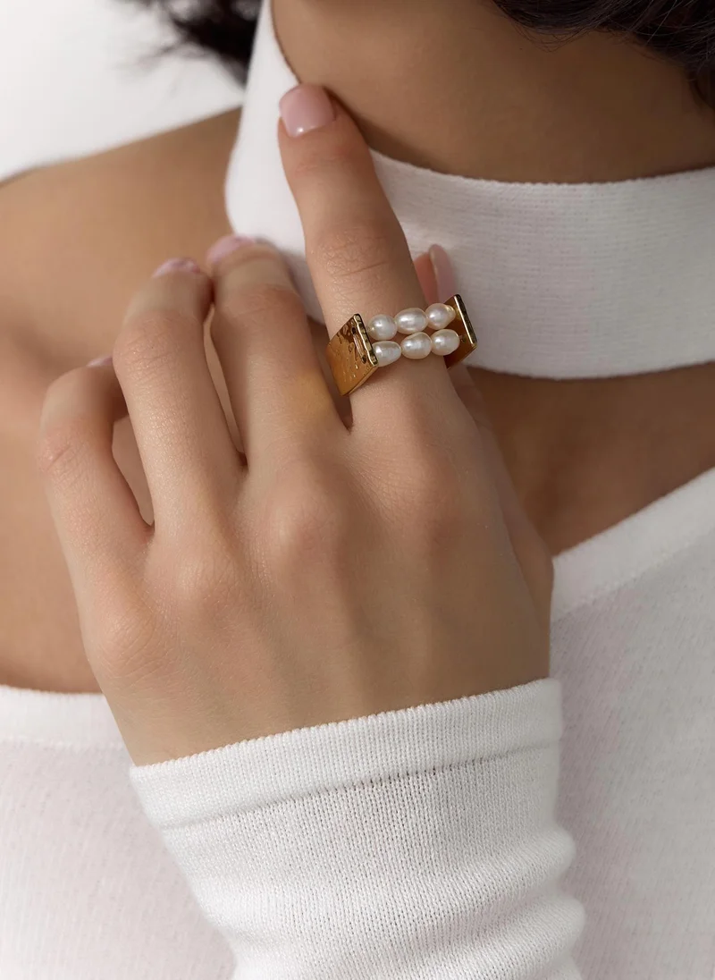 Wide golden ring with pearls in the centre