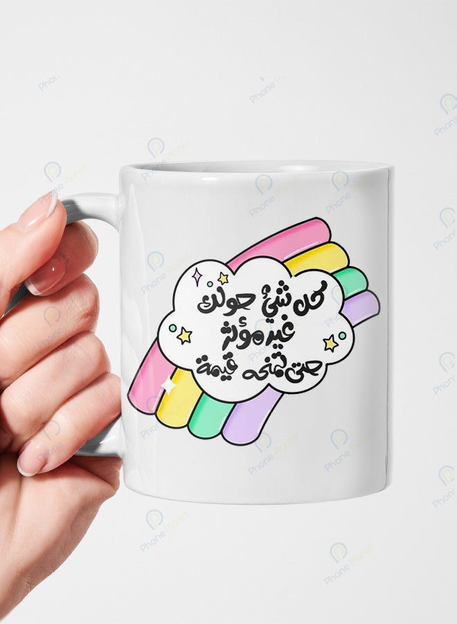 كوب من السيراميك مطبوع عليه عبارة كل شئ حولك غير مؤثر ويتميز بمقبض مريح