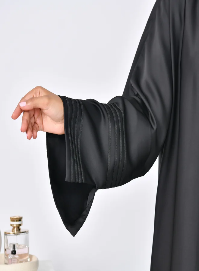 عبايات حوراء عباية لف سوداء بقصة كلوش مزينة بقيطان على الاكمام الواسعة