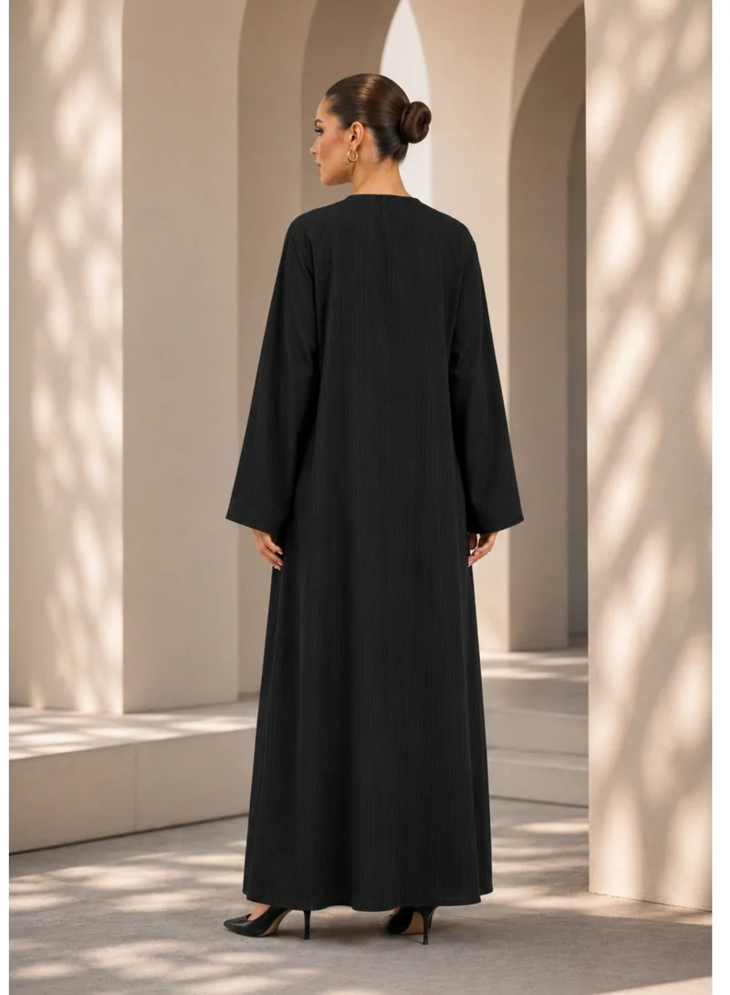 Nikias  Black crepe abaya with self embossed fabric. Casual wear with matt golden buttons for Women | Best Price UAE
