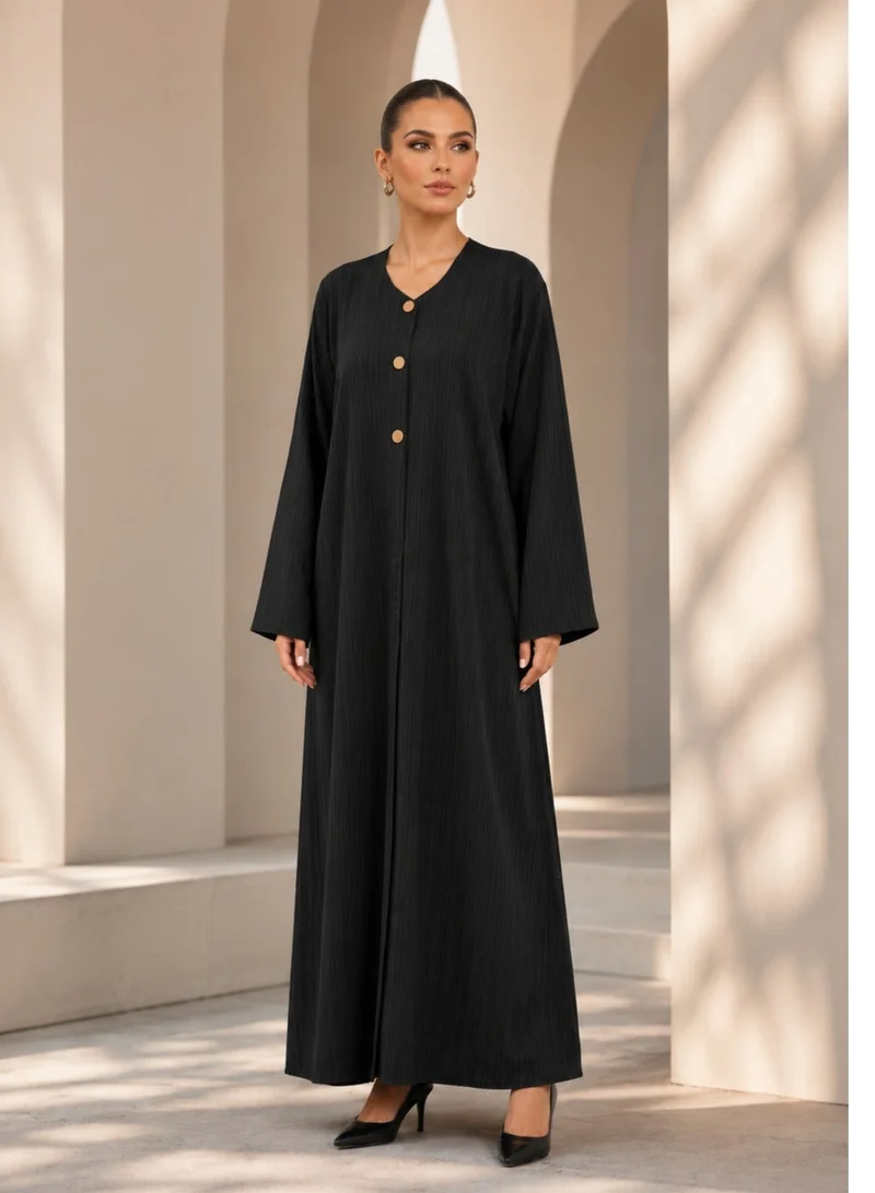 Nikias Black crepe abaya with self embossed fabric. Casual wear with matt golden buttons