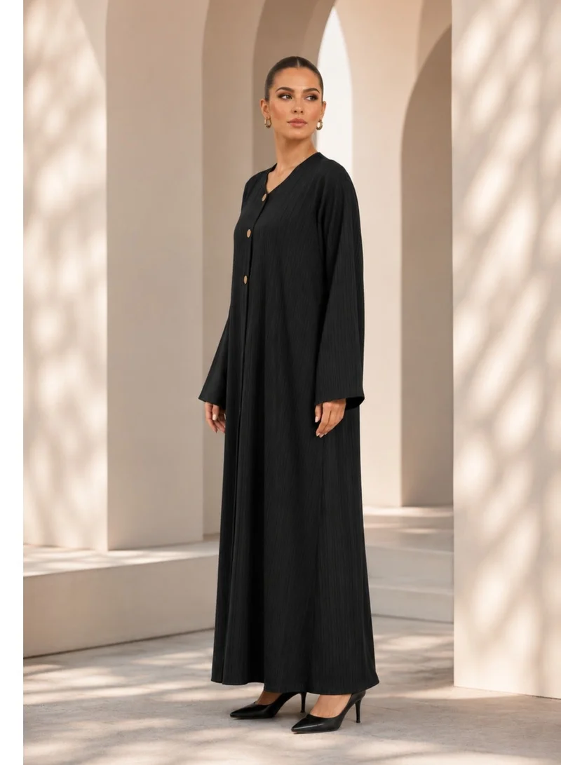Nikias Black crepe abaya with self embossed fabric. Casual wear with matt golden buttons