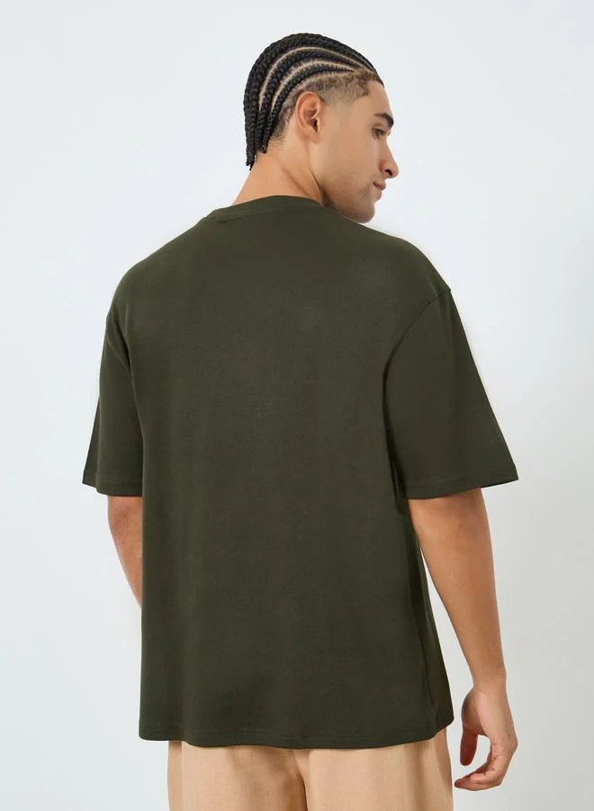 Styli  Men Olive Graphic Embossed Oversized T-Shirt for Men | Best Price UAE