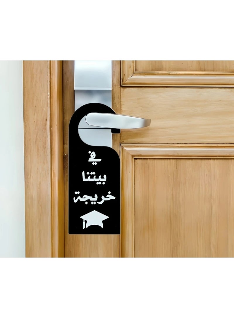 كلاوديز تعليقة أكريليك لمقبض الباب – تصميم "في بيتنا خريجة" مع عبارة محفّزة، مثالية لزينة التخرج، حفلة تخرج - Image 1