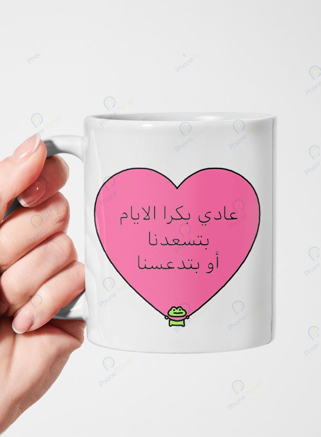 كوب من السيراميك مطبوع عليه عبارة عادي بكرا الأيام بتسعدنا ويتميز بمقبض مريح