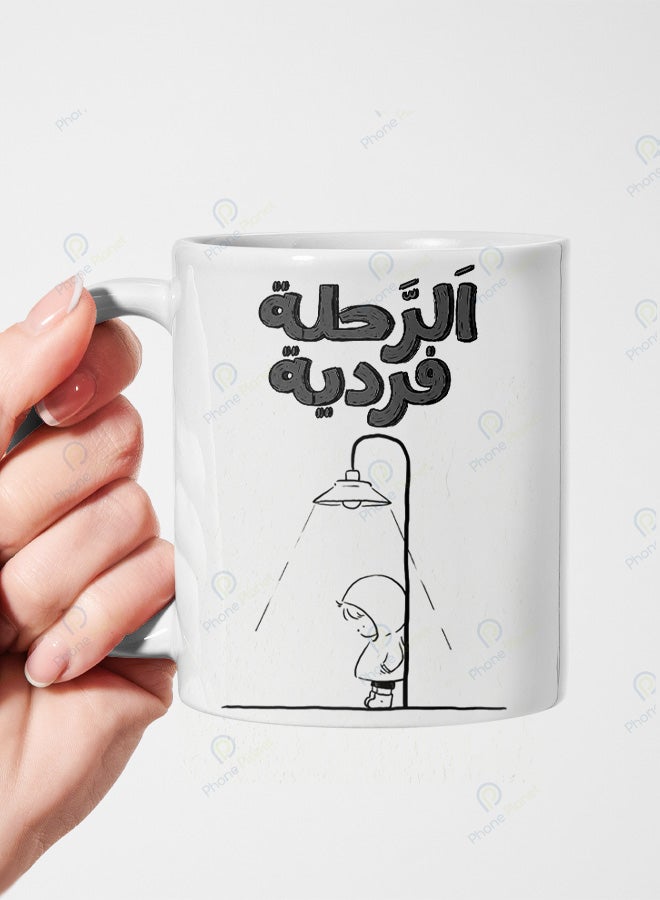 كوب من السيراميك مطبوع عليه عبارة الرحلة فردية ويتميز بمقبض مريح
