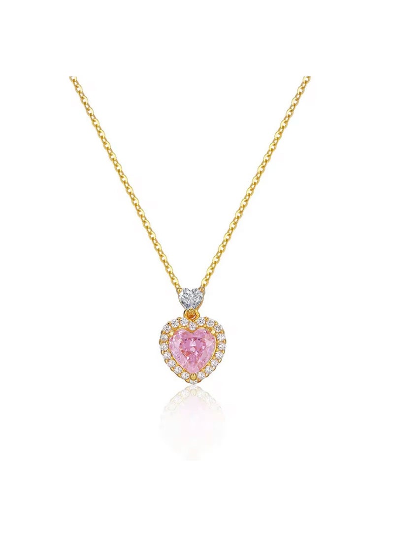 Luxuria An elegant necklace featuring a heart-shaped pendant set with a pink stone, surrounded by a frame of smaller, sparkling stones, on a gold-tone chain. With gemstones such as pink sapphires and zircon. - Image 1