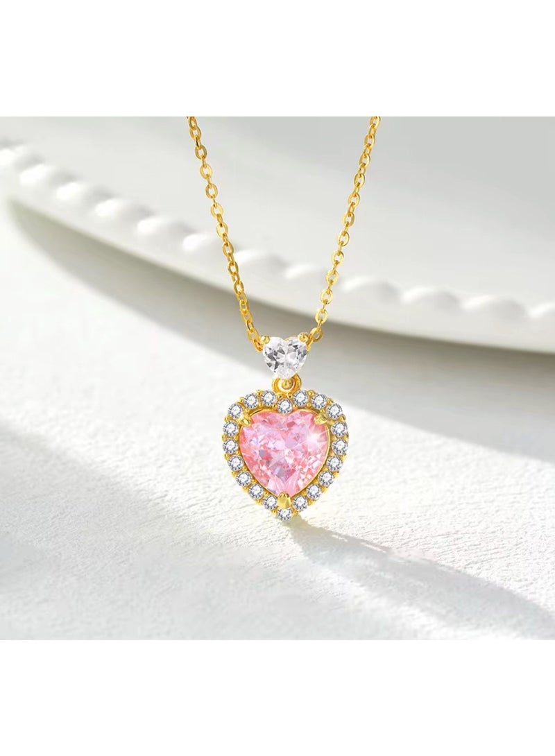 Luxuria An elegant necklace featuring a heart-shaped pendant set with a pink stone, surrounded by a frame of smaller, sparkling stones, on a gold-tone chain. With gemstones such as pink sapphires and zircon. - Image 2