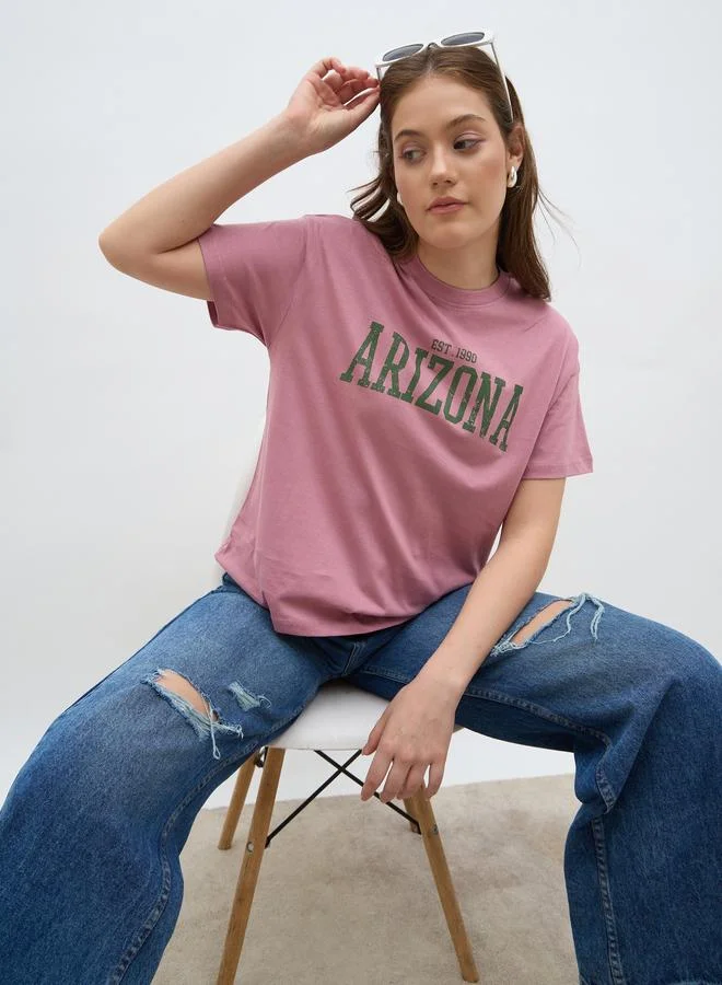 ستايلي تيشيرت بأكمام قصيرة بقصة واسعة وطبعة شعار ستايلي